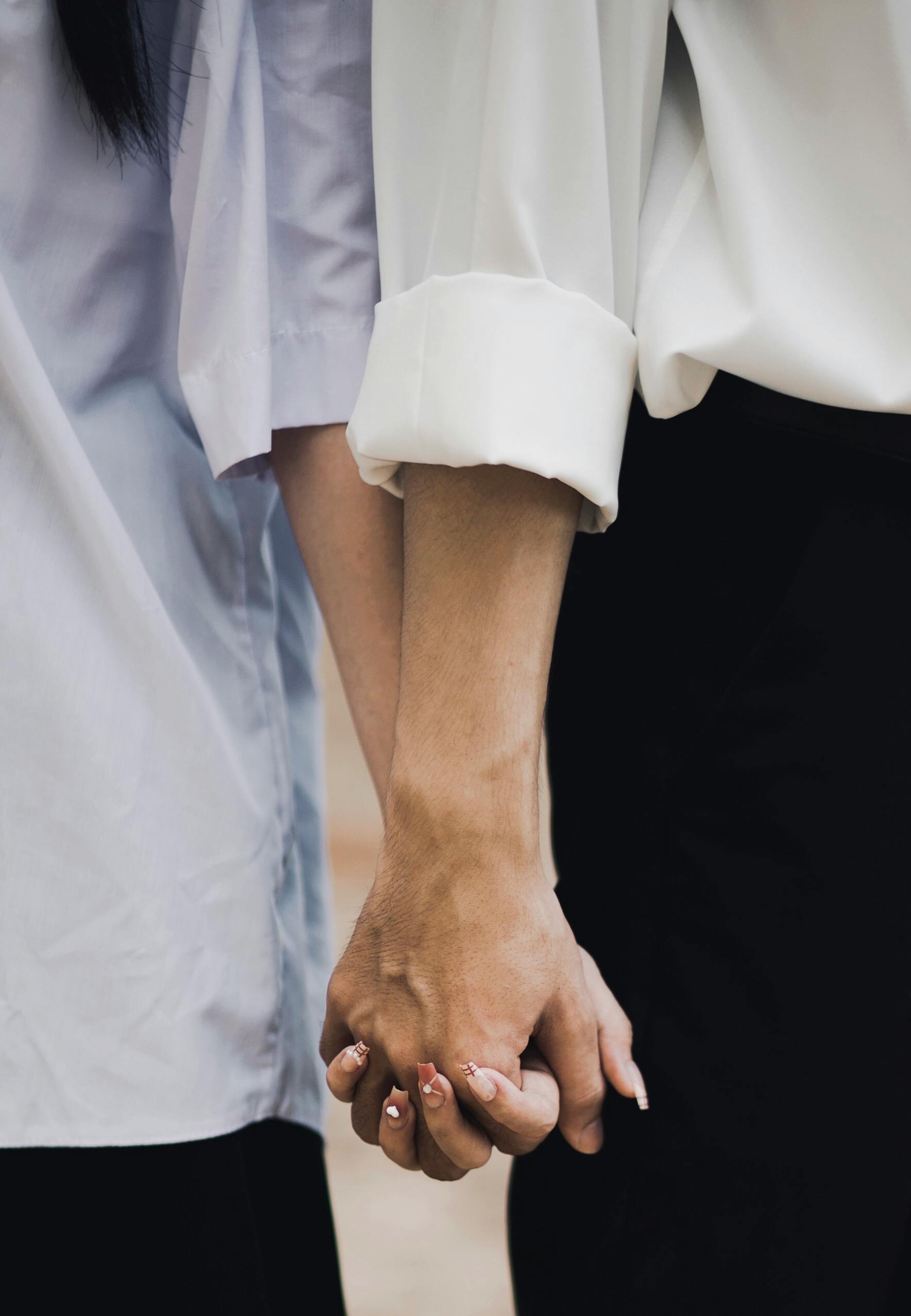 Dos personas dándose la mano como símbolo de reconciliación y conexión en terapia de pareja.